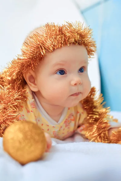 Portrait of beautiful newborn baby in hat of tinsel