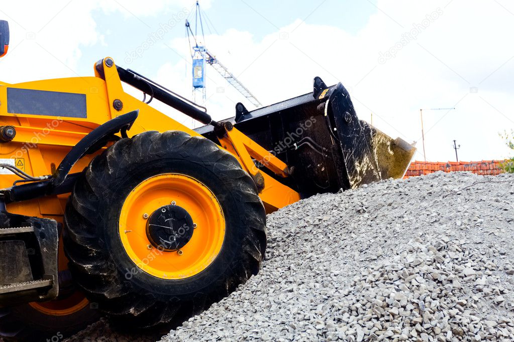 A bulldozer picking up gravel on jobsite.