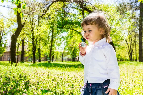 Criança soprando bolhas de sabão . — Fotografia de Stock