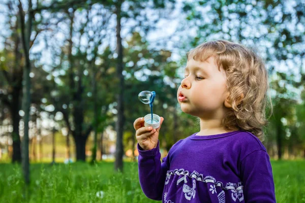 Dítě fouká mýdlové bubliny. — Stock fotografie