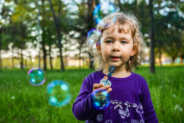 Dítě fouká mýdlové bubliny. — Stock fotografie