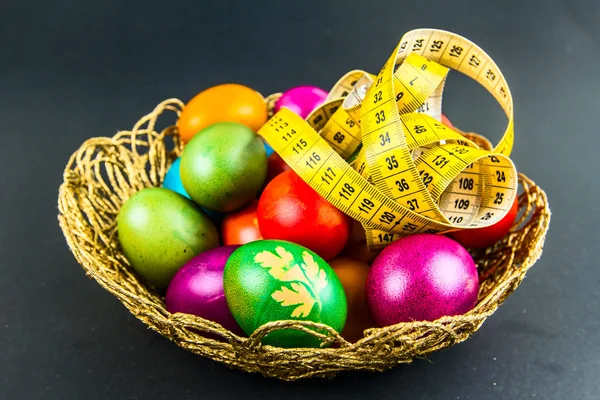 Decorated Easter eggs in a woven basket — Stock Photo, Image