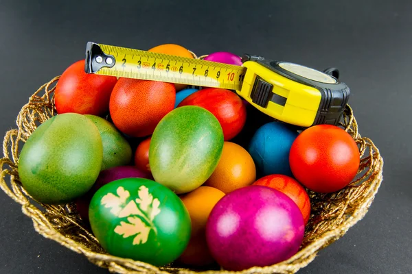 Decorated Easter eggs in a woven basket — Stock Photo, Image