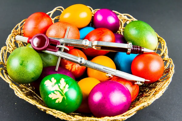 Decorated Easter eggs in a woven basket — Stock Photo, Image