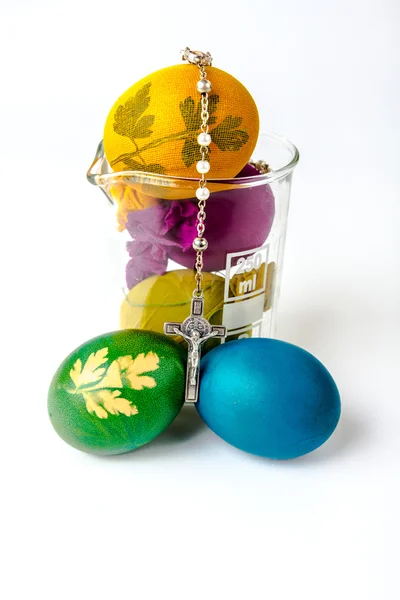 Easter eggs with rosary on lab glass — Stock Photo, Image