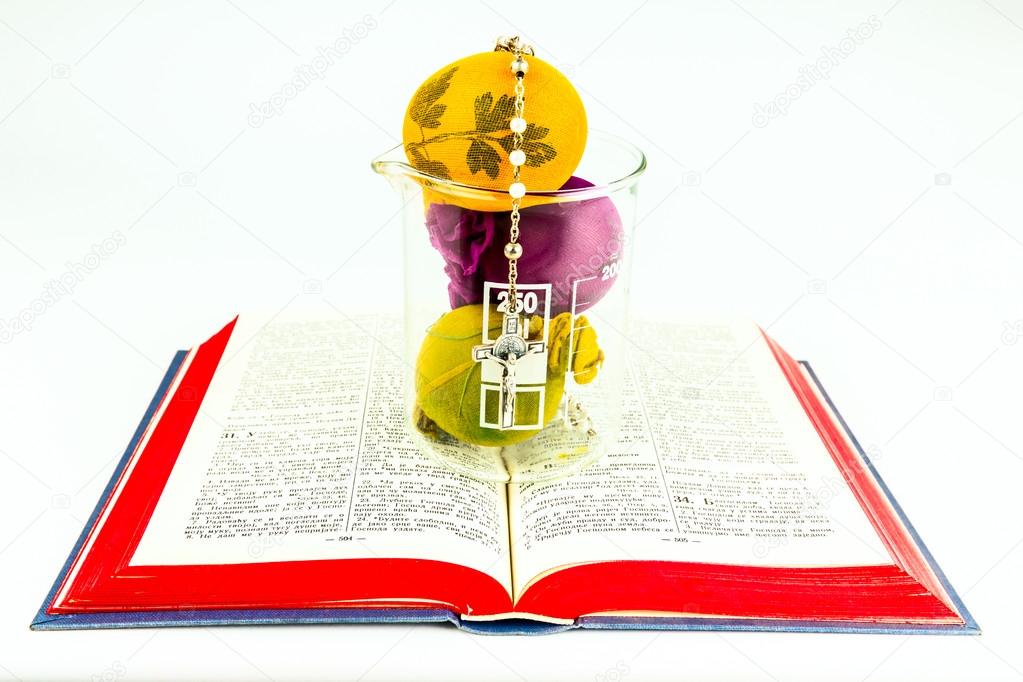 Easter eggs in lab glass with rosary on a holy Bible