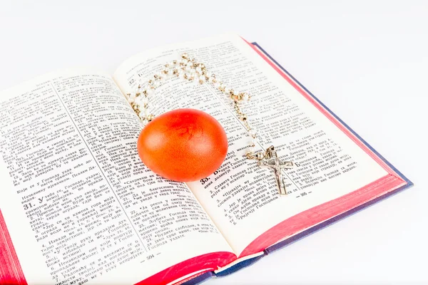 Easter egg with rosary on a holy Bible — Stock Photo, Image