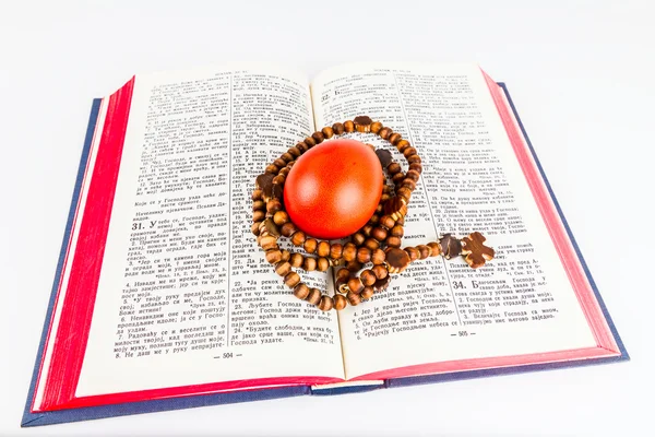 Easter egg with rosary on a holy Bible — Stock Photo, Image