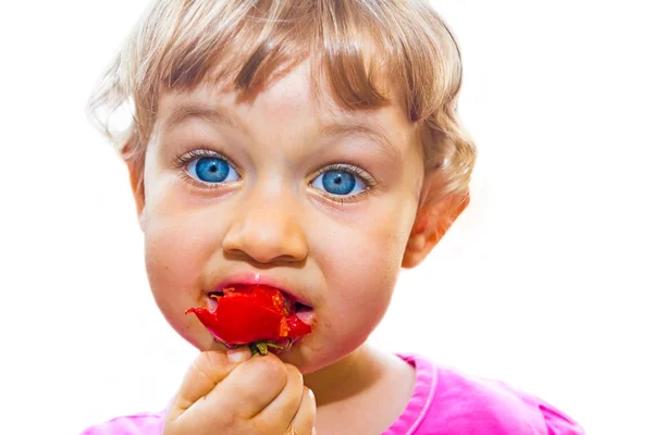 Klein meisje eten tomaat — Stockfoto