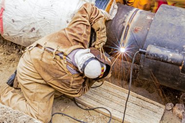 Metalworker working on a pipeline  clipart
