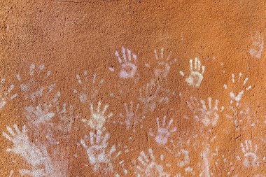 Çocukların tebeşirle oynaması, palmiyelerin toz rengi, kaba duvar cephesindeki el izleri, çocukluk tasarımı.