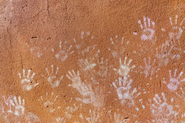 Çocukların tebeşirle oynaması, palmiyelerin toz rengi, kaba duvar cephesindeki el izleri, çocukluk tasarımı.