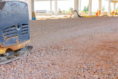 Kullanılmış plaka kompaktörü, titreşimli çekiç, atlama jakı makinesi, şantiyede gölgede yerleştirilen elektrikli alet.