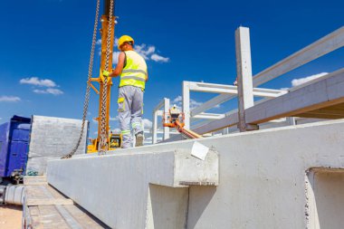 İşçi Vinç kanca kamyon römork gelen boşaltma beton kiriş için hazırlanıyor.
