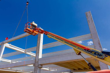 Vinçler-Mobil vinç işletim ve derleme beton kiriş yüksek yerde çalışıyor. Yükseklik işçi iskelet bina truss çiziyor.