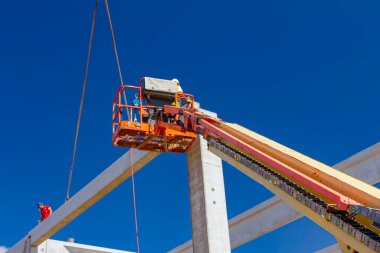 Vinçler-Mobil vinç işletim ve derleme beton kiriş yüksek yerde çalışıyor. Yükseklik işçi iskelet bina truss çiziyor.