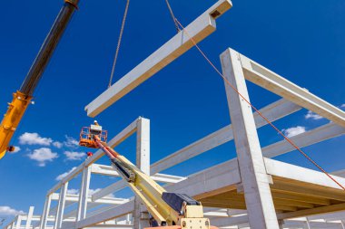 Vinçler-Mobil vinç işletim ve derleme beton kiriş yüksek yerde çalışıyor. Yükseklik işçi iskelet bina truss çiziyor.