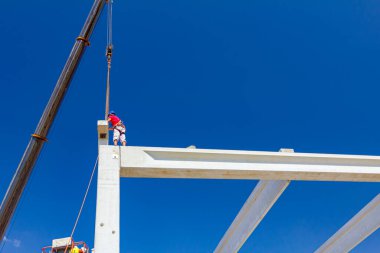 Vinçler-Mobil vinç işletim ve derleme beton kiriş yüksek yerde çalışıyor. Yükseklik işçi iskelet bina truss çiziyor.