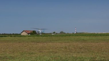 Ecka, Voyvodina, Sırbistan - 21 Ağustos 2015: Ulusal paraşüt şampiyonasında, helikopter yeşil çayırdan havalandı ve yatay olarak alçaktan uçtu.