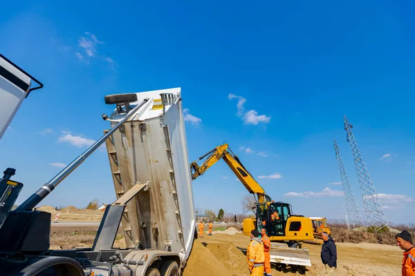 ダンパートラックは建設現場で土や砂を卸しています — ストック写真