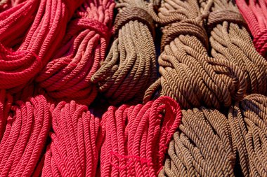 Close up shot of heap of braided hemp ropes made for sale at outdoor flea market. Manila ropes