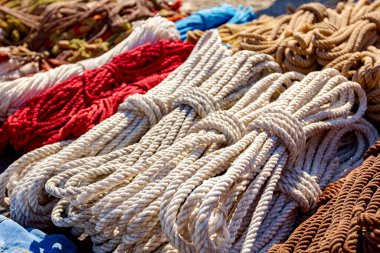 Close up shot of heap of braided hemp ropes made for sale at outdoor flea market. Manila ropes