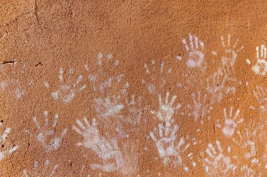 Çocukların tebeşirle oynaması, palmiyelerin toz rengi, kaba duvar cephesindeki el izleri, çocukluk tasarımı.