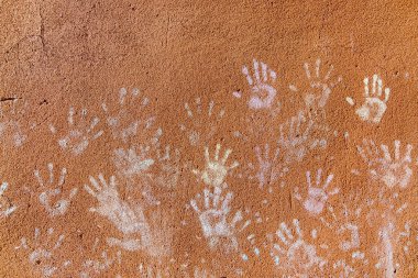 Çocukların tebeşirle oynaması, palmiyelerin toz rengi, kaba duvar cephesindeki el izleri, çocukluk tasarımı.