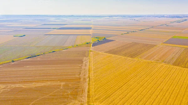 田舎道の上からの眺めは 収穫後の農地と田舎道の間を通っています — ストック写真