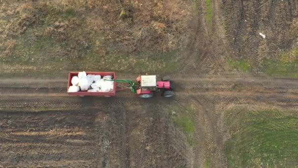 Nad Vrchním Pohledem Traktor Táhne Zemědělský Přívěs Plný Vycpaných Pytlů — Stock video