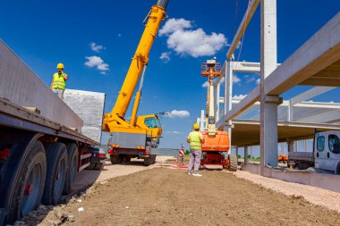 Çalışan mobil vinç halat boyu derleme büyük inşaat için beton kiriş yönetmek için yardımcı oluyor.