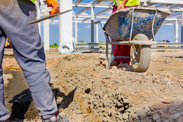 Construction Worker Using Shovel Unloading Cement Wheelbarrow Construction Site — Stock Photo, Image