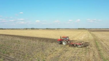 Traktörün görüş alanının üstünde, makineyi çekiyor, tarlayı yıpratıyor, toprağı gelecek sezon ekime hazırlıyor..