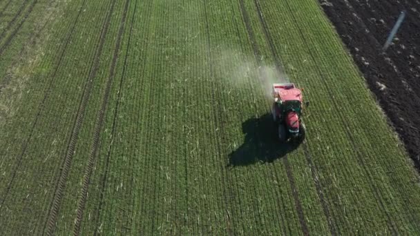 从上往下看 娃娃式移动 在拖拉机上抛掷 用嫩绿小麦给耕地施肥 拖着挂载的农业机械撒播化肥 — 图库视频影像