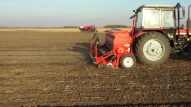 Çekicinin yan tarafındaki çekimde tohum makinesini tarlaya, toprağa, yeni buğday ekimine çekiyorlar..