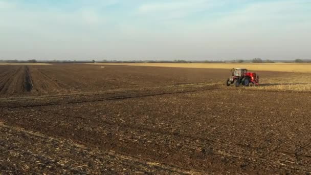 軌道回転は 新しいコムギ作物を植える 耕作可能なフィールド 土壌上の種子ドリルマシンを引くとしてトラクターのドリー移動ショット — ストック動画