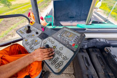 İşçi, joystick işletim gidon, asfalt yol Döşeme makinesi operatörü kontrol ediyor.