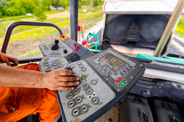 İşçi, joystick işletim gidon, asfalt yol Döşeme makinesi operatörü kontrol ediyor.