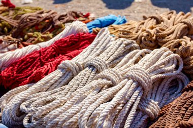 Close up shot of heap of braided hemp ropes made for sale at outdoor flea market. Manila ropes