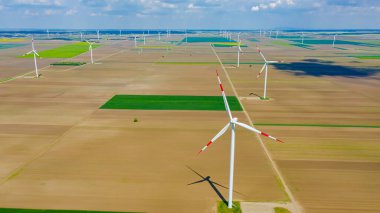 Yüksek rüzgar gücü türbinleri tarımsal alanlar arasında duruyor ve sürdürülebilir kalkınma için temiz yenilenebilir elektrik enerjisi üretiyorlar..