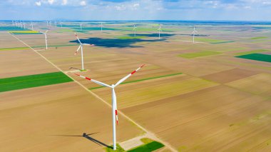Yüksek rüzgar gücü türbinleri tarımsal alanlar arasında duruyor ve sürdürülebilir kalkınma için temiz yenilenebilir elektrik enerjisi üretiyorlar..