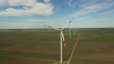 Yukarıda, büyük rüzgar santrallerinin üzerinde tarımsal alanların arasında durarak temiz, yeşil, yenilenebilir elektrik enerjisi üretiliyor..