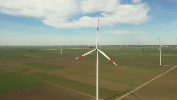 上記のビューでは 大胆な動きは 大規模な風力タービンの農場では 農業分野の間で立っている クリーン 再生可能エネルギーを生成します — ストック動画