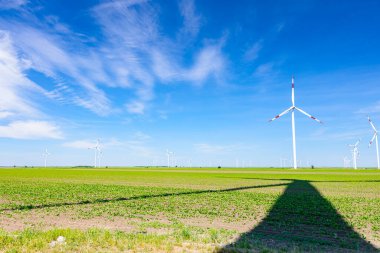 Rüzgar jeneratörü, türbinler, dönen bıçaklar, pervaneler, yenilenebilir temiz enerji kinetik enerjiyi dönüştüren uzun gölgeler.