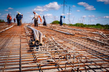 Paslı çelik borular ikinci dereceden takviye ağlarının üzerine yerleştiriliyor. İnşaat alanındaki köprünün gücü için..