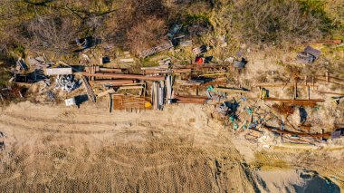 İnşaat alanında parçalanmış paslı takviye malzemeleriyle birlikte açık hava deposunun üst katında..