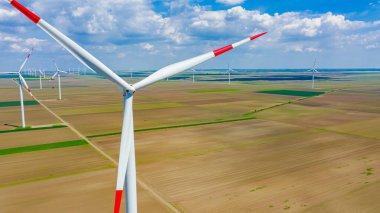 Yüksek rüzgar gücü türbinleri tarımsal alanlar arasında duruyor ve sürdürülebilir kalkınma için temiz yenilenebilir elektrik enerjisi üretiyorlar..