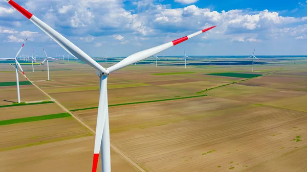 Yüksek rüzgar gücü türbinleri tarımsal alanlar arasında duruyor ve sürdürülebilir kalkınma için temiz yenilenebilir elektrik enerjisi üretiyorlar..