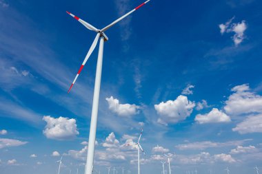 Rüzgar jeneratörü, türbinler, dönen bıçaklar, pervaneler, bulutlu ve mavi gökyüzüne karşı yenilenebilir temiz enerji kinetik enerjiyi dönüştürür..