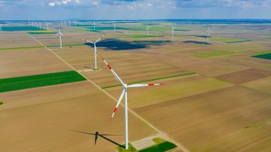Yüksek rüzgar gücü türbinleri tarımsal alanlar arasında duruyor ve sürdürülebilir kalkınma için temiz yenilenebilir elektrik enerjisi üretiyorlar..